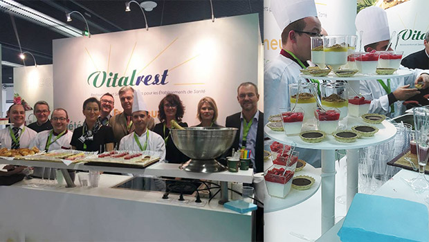 Un groupe de personnes debout devant un étalage de desserts.