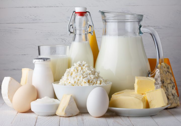 Produits laitiers tels que le lait, les œufs et le fromage sur une table en bois.