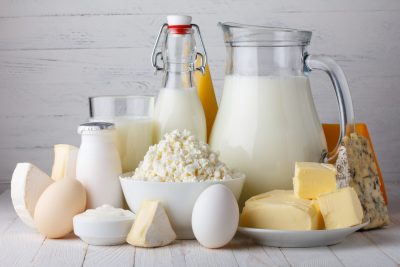 Produits laitiers tels que le lait, les œufs et le fromage sur une table en bois.