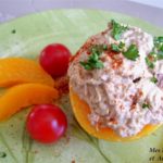 Salade de thon aux pêches et tomates sur une assiette verte.