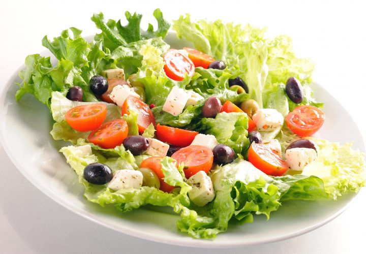 Une assiette avec une salade dessus.