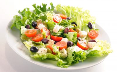 Une assiette avec une salade dessus.