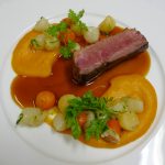Plat de magret de canard à l'orange et d'une fine purée de potiron et billes de légumes racines glacées