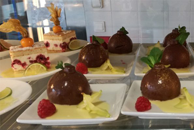 Une présentation de desserts dans une vitrine en verre.