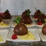 Une présentation de desserts dans une vitrine en verre.