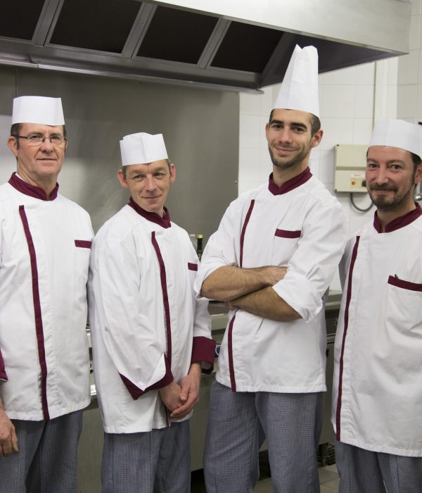 Un groupe de chefs debout dans une cuisine.