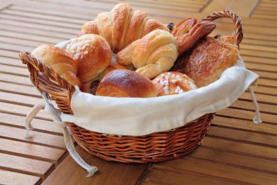 Un panier plein de pâtisseries sur une table en bois.