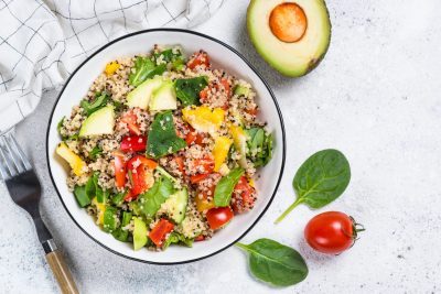 Salade de quinoa avec avocat, tomates et épinards.