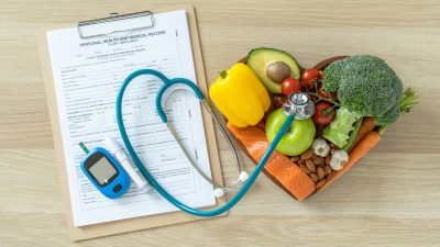 Un presse-papiers avec un stéthoscope et des légumes dessus.