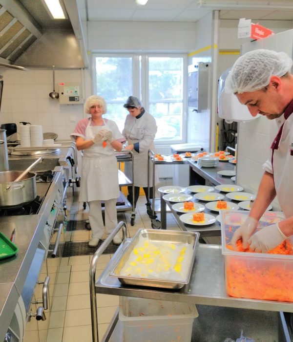 Un homme prépare de la nourriture dans une cuisine.