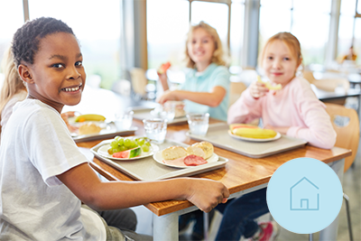 Un groupe d’enfants assis à une table en train de manger.