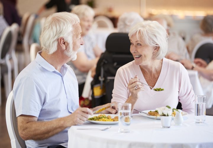 Un couple âgé savourant un repas dans un restaurant.