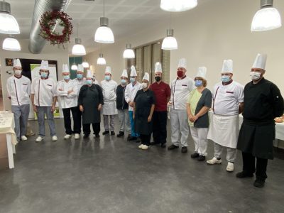 Un groupe de chefs posant pour une photo dans une cuisine.