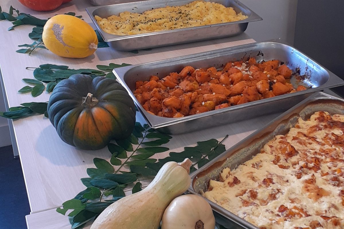 Une table pleine de plats avec des citrouilles et des courges.