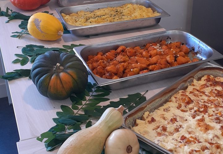 Une table pleine de plats avec des citrouilles et des courges.