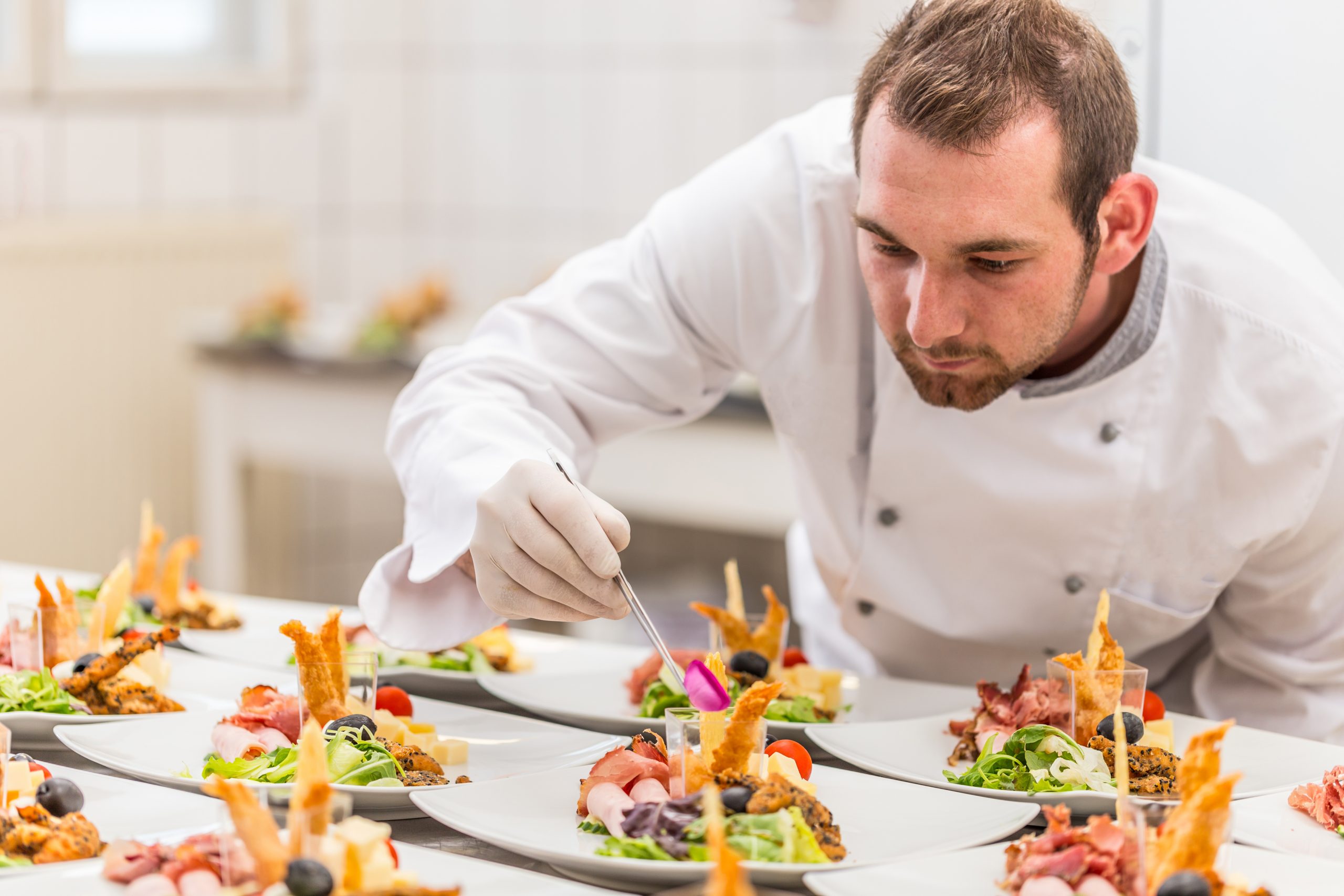 Un expert de la restauration collective pour les maisons de retraite et EHPAD préparant des plats dans un restaurant.