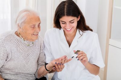 Une infirmière aide une femme âgée avec ses médicaments.