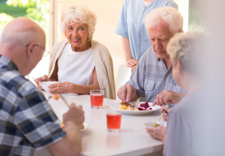 Un groupe de personnes âgées mangeant à table.