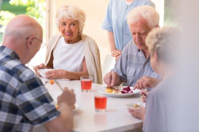 Un groupe de personnes âgées mangeant à table.