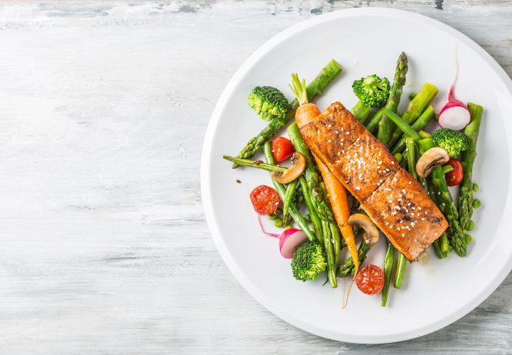 Saumon et légumes sur une assiette blanche.