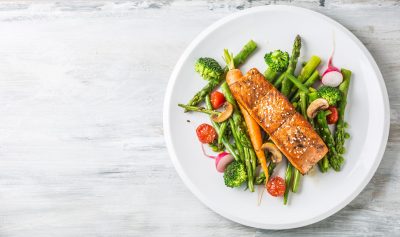 Saumon et légumes sur une assiette blanche.