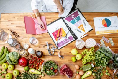 Une femme est assise à une table avec beaucoup de nourriture dessus.