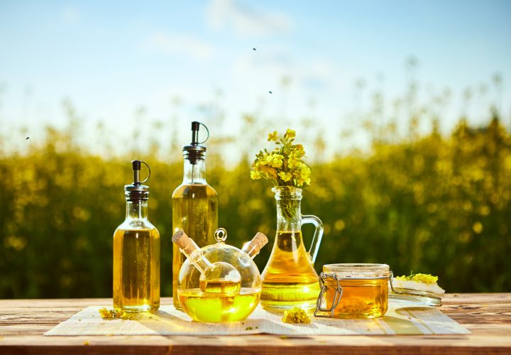 Huile de canola et miel sur une table en bois.