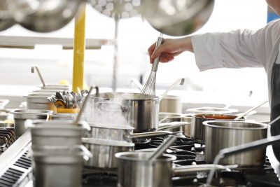 Un chef prépare des plats dans une cuisine commerciale.