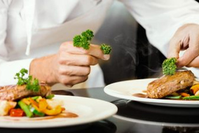 Un chef prépare des plats dans une assiette.