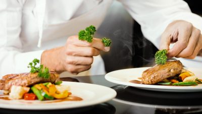 Un chef prépare des plats dans une assiette.