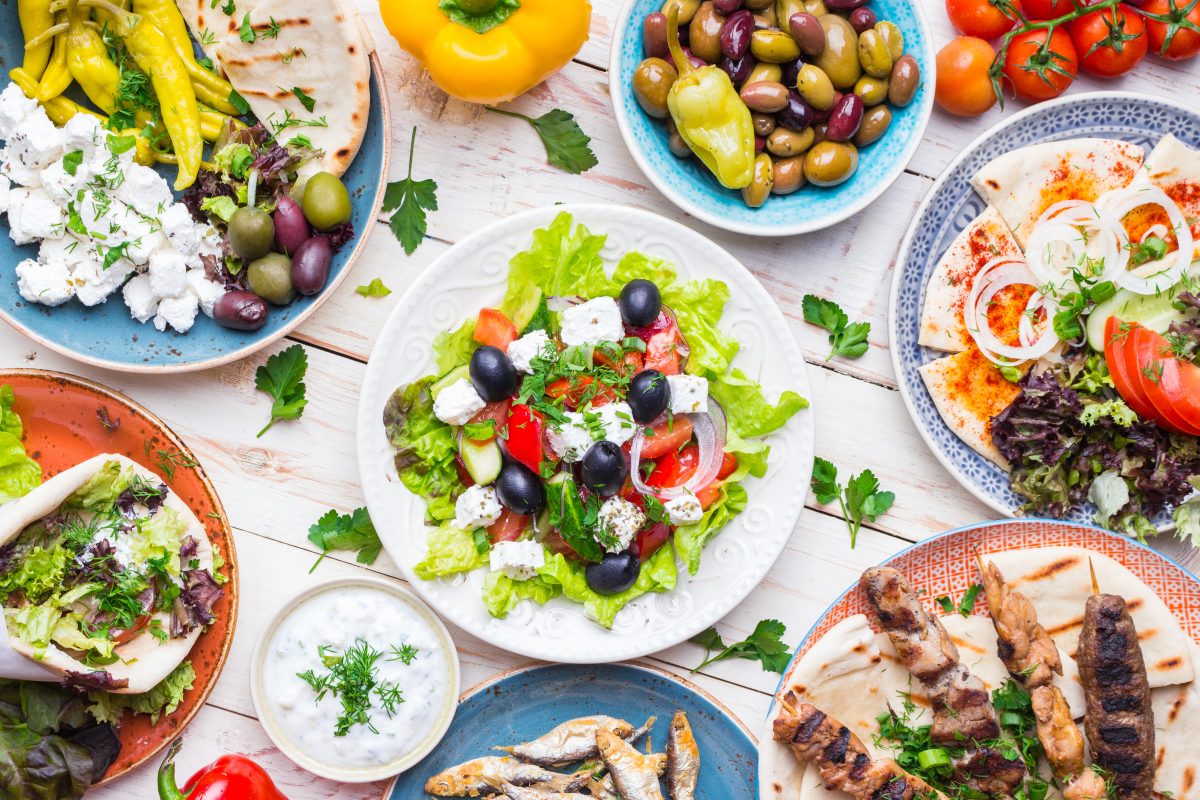 Une variété de plats grecs sur une table en bois.