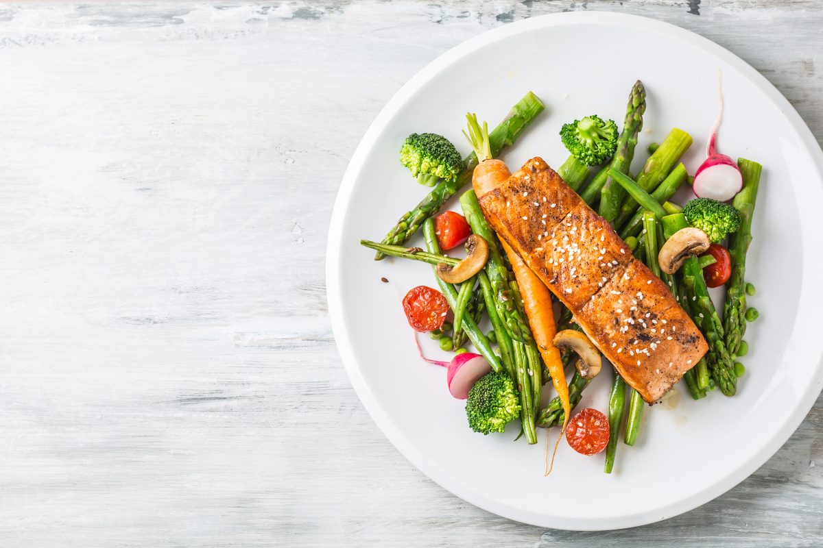 Saumon et légumes sur une assiette blanche.