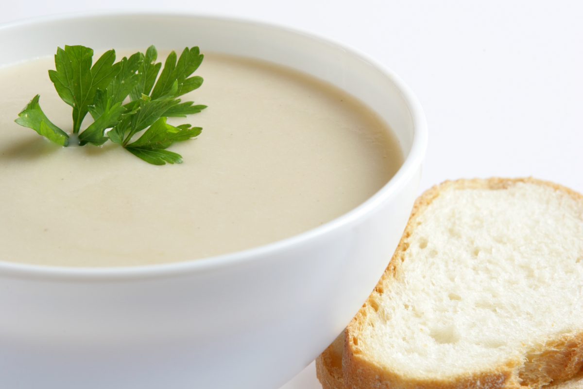 Un bol de soupe avec du pain et du persil.