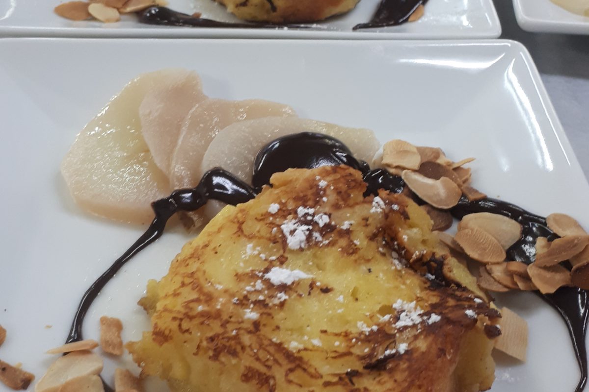 Une assiette de pain perdu avec sauce au chocolat et amandes.