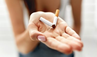 Une femme tenant une cigarette à la main.