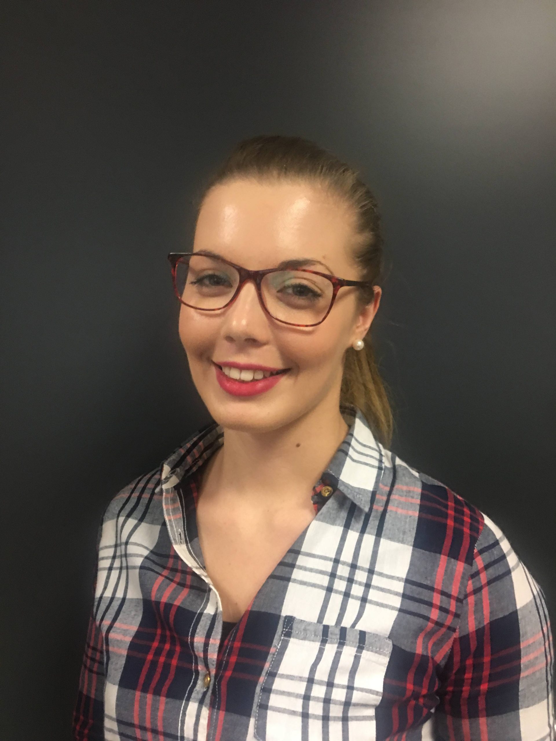 Une femme portant des lunettes et une chemise à carreaux.