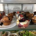 Un étalage de muffins et de fruits sur un comptoir.