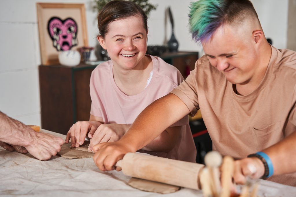 Un homme et une femme travaillent ensemble sur une table de restauration dans des établissements accueillant des personnes handicapées.