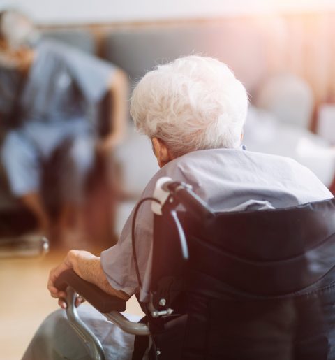 Une femme âgée en fauteuil roulant et une infirmière la respectent, dans un cadre de restauration pour établissements accueillant des personnes en situation