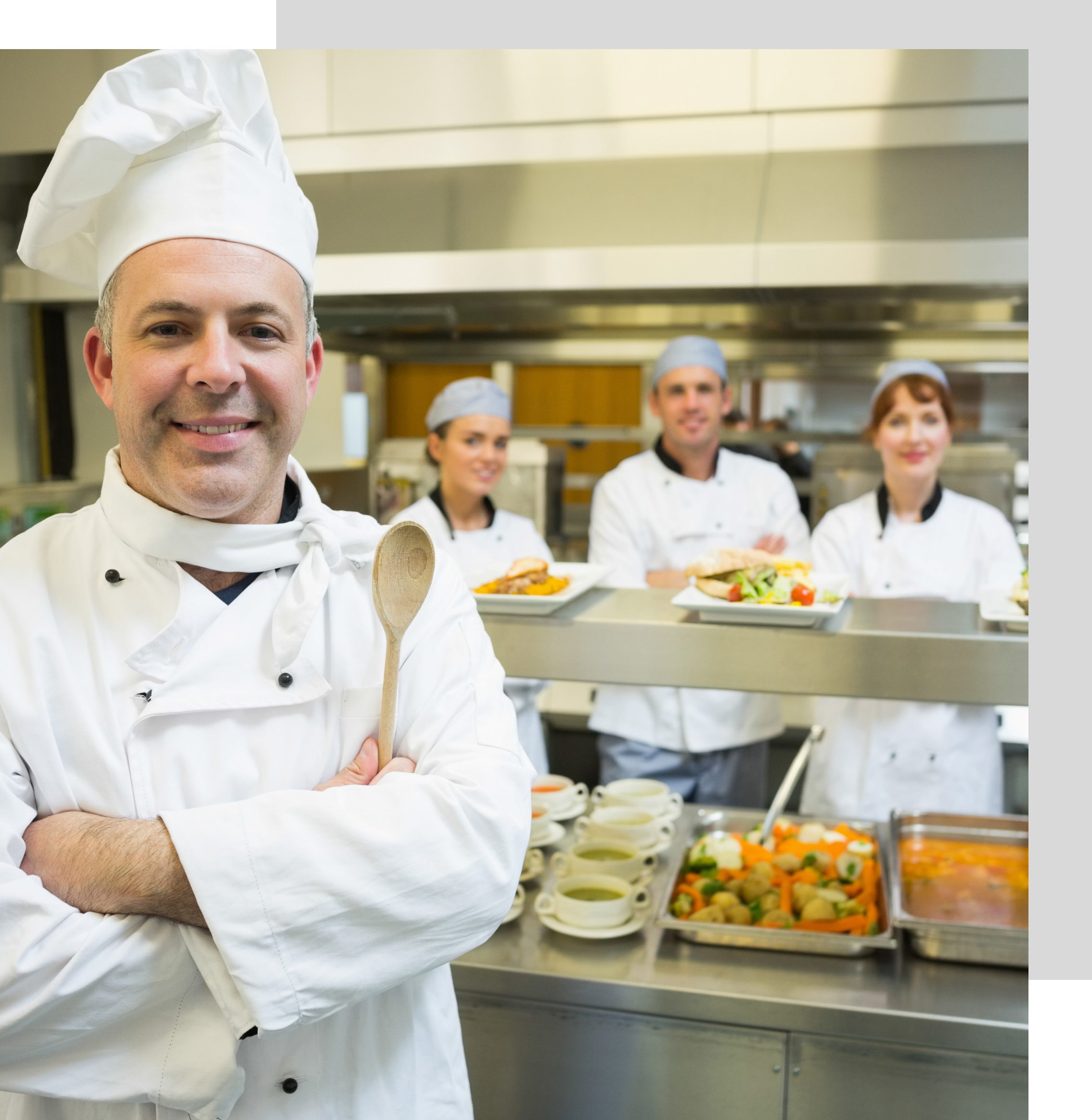 Un groupe de chefs debout devant une cuisine.