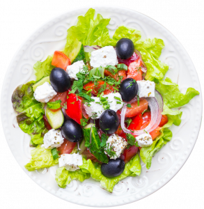 Une assiette de salade grecque avec olives, tomates et fromage feta.