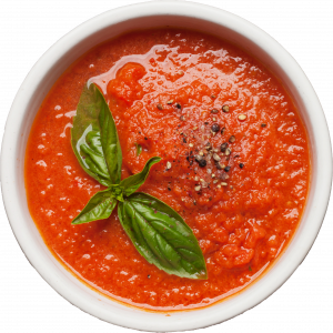 Un bol de soupe aux tomates et aux feuilles de basilic.
