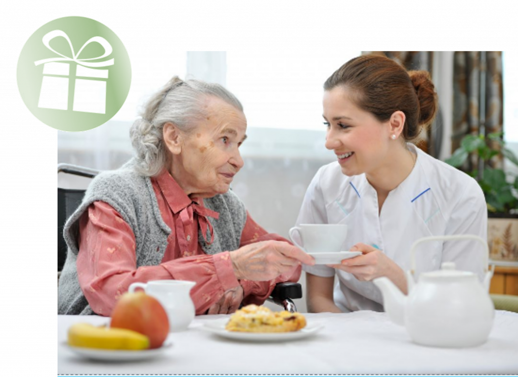 Une infirmière aide une femme âgée avec une tasse de thé.