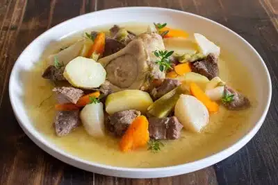 Un bol de ragoût, témoignage du déploiement de la cuisson lente à juste température, avec de la viande, des pommes de terre et des carottes.